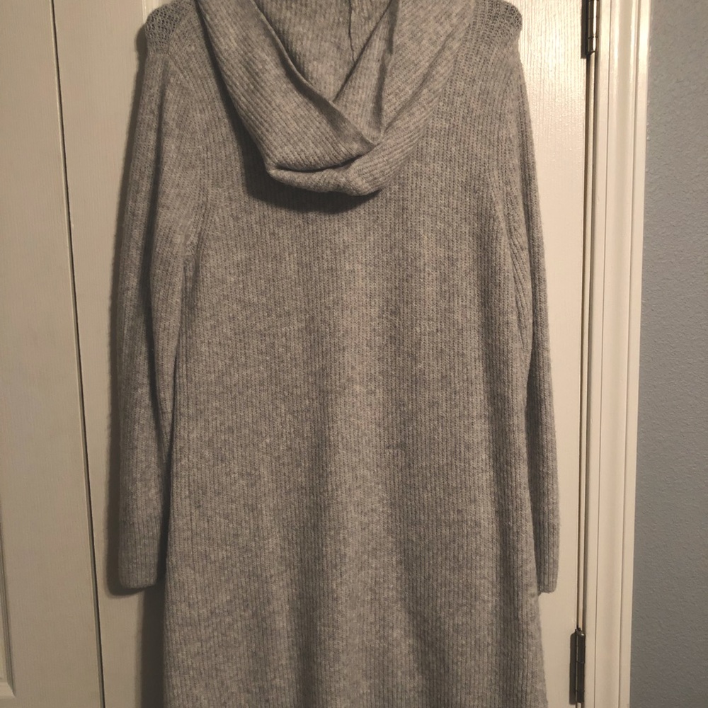 Cardigan woman sweater with two pockets and hood. It’s is long and grey/white